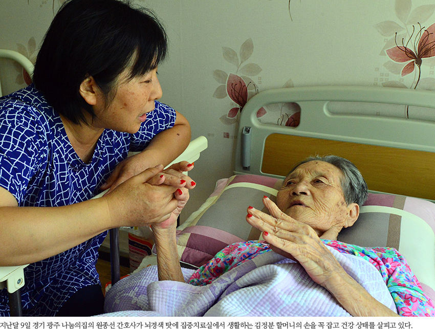 지난달 9일 경기 광주 나눔의집의 원종선 간호사가 뇌경색 탓에 집중치료실에서 생활하는 김정분 할머니의 손을 꼭 잡고 건강 상태를 살피고 있다. 